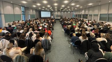 
		Participants at the Child Protection Day listen to a presentation at the front of the stage
	